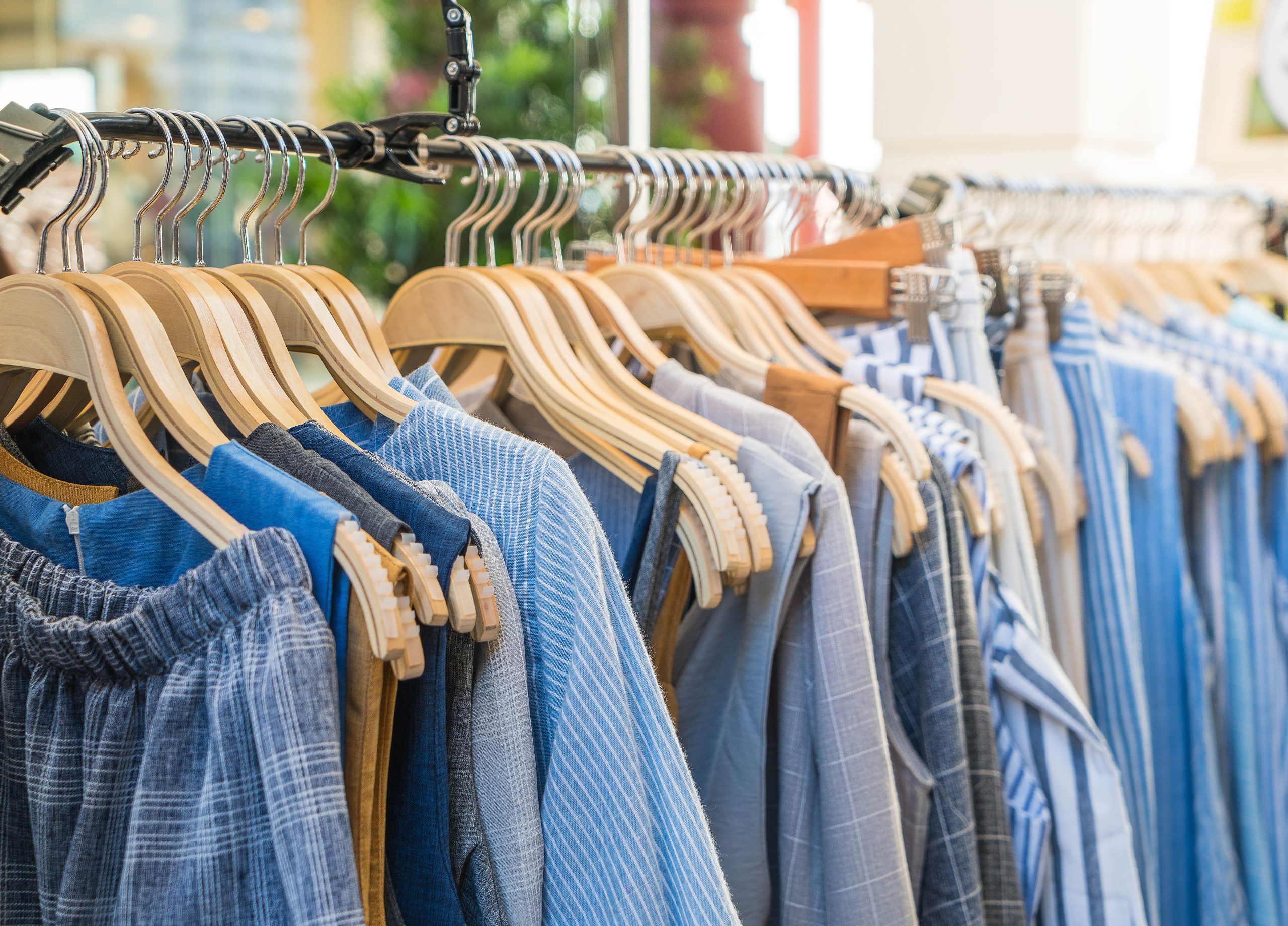Blue linen clothing on wooden hangers.